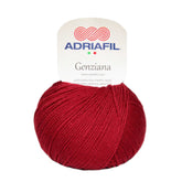 Gomitolo di lana merino extrafine Adriafil Genziana rosso scuro, tinta unita e dalla trama ritorta uniforme.